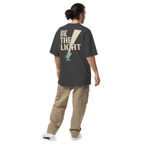TRØBL oversized t-shirt met gele en roze “BE THE LIGHT” print, unisex boxy fit, garment-dyed katoen met dropped shoulders.