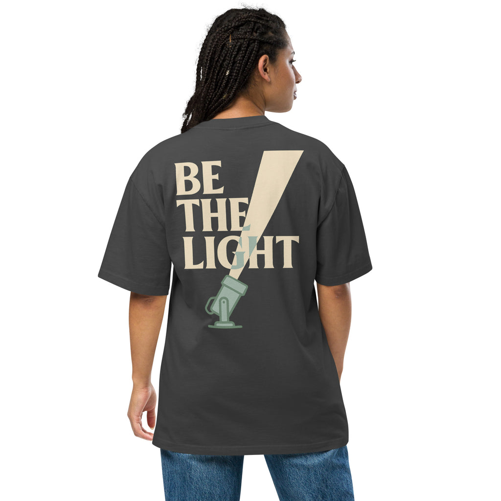 TRØBL oversized t-shirt met gele en roze “BE THE LIGHT” print, unisex boxy fit, garment-dyed katoen met dropped shoulders.