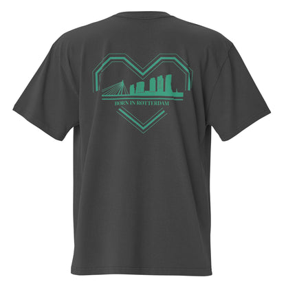 "Groen-wit ontwerp van een gebroken hart met de skyline van Rotterdam en de tekst 'BØRN IN RØTTERDAM' op de borst van een oversized TRØBL T-shirt."