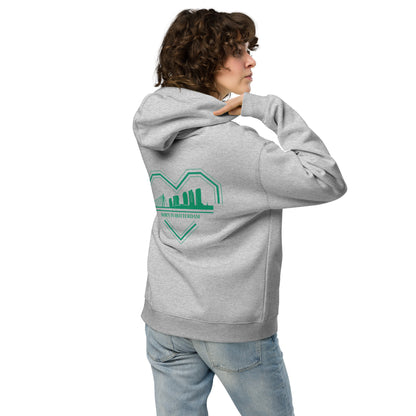 "Groen-wit ontwerp van een gebroken hart met skyline van Rotterdam en de tekst 'BØRN IN RØTTERDAM' eronder, gedrukt op een oversized TRØBL hoodie."